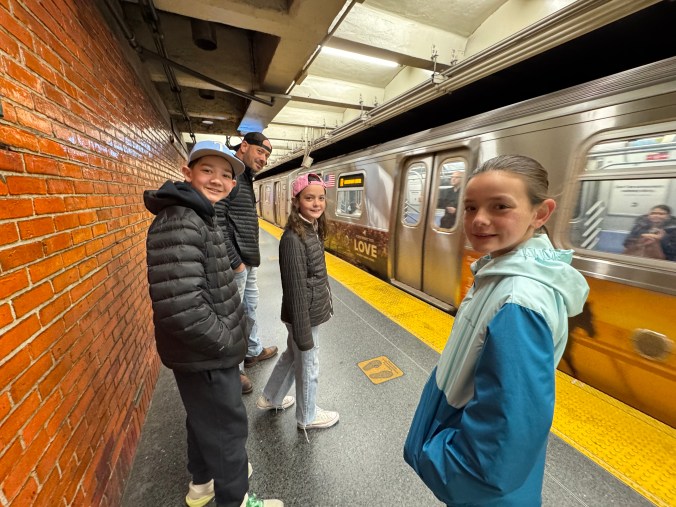 Family with kids waiting on subway platform in New York City using public transportation