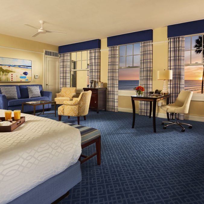 Spacious bedroom at the Grande Colonial hotel featuring comfortable beds and coastal-inspired decor.