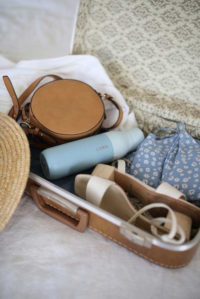 Organized suitcase packed with outfits for travel including clothes and accessories