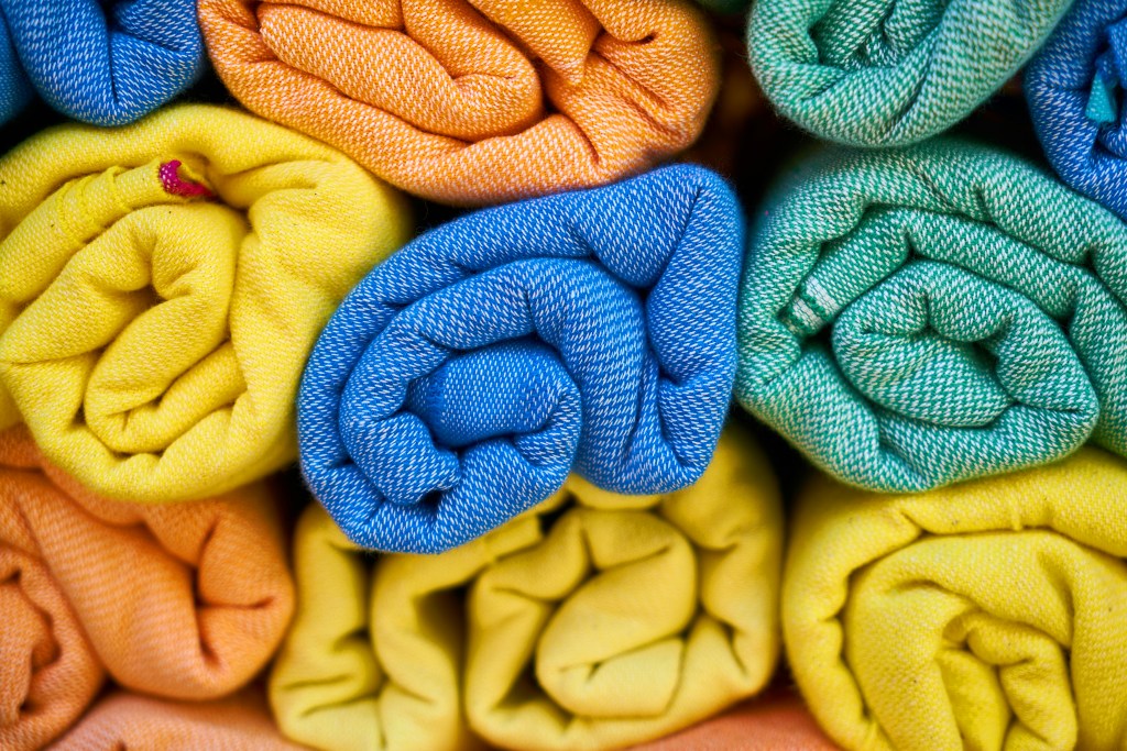 Rolled colorful clothes packed efficiently to save space in suitcase