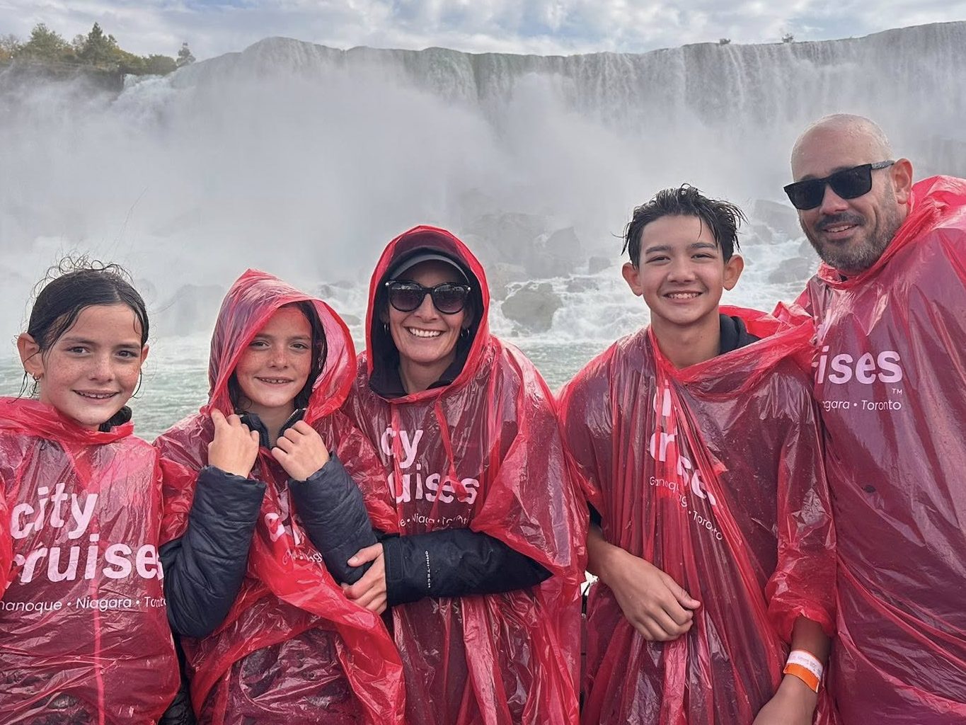 Family wearing ponchos at Niagara Falls during a boat tour experience