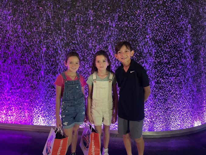 Kids standing in front of colorful waterfall display on the Las Vegas Strip