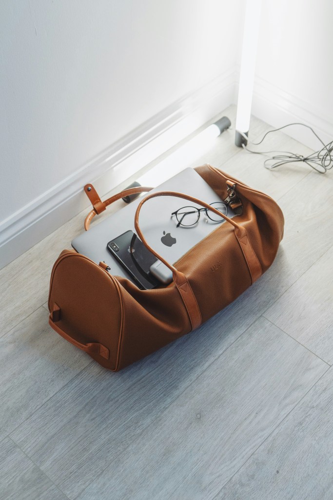 Travel bag with laptop, phone, and essentials packed