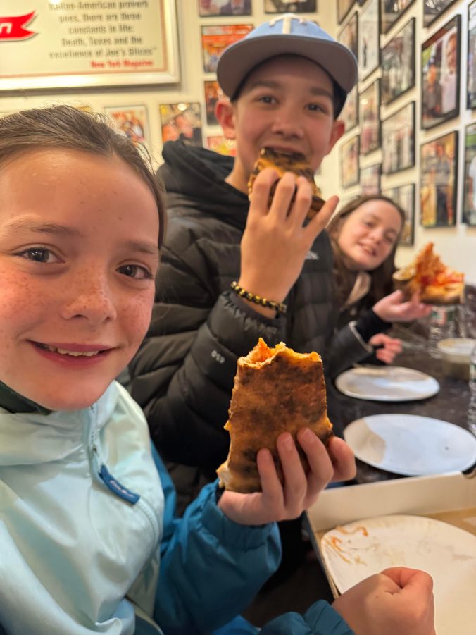 Kids eating pizza during a family trip to New York City