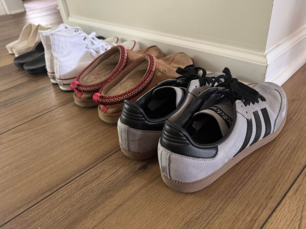 Minimal shoes lined up for travel packing including sneakers and slip-ons