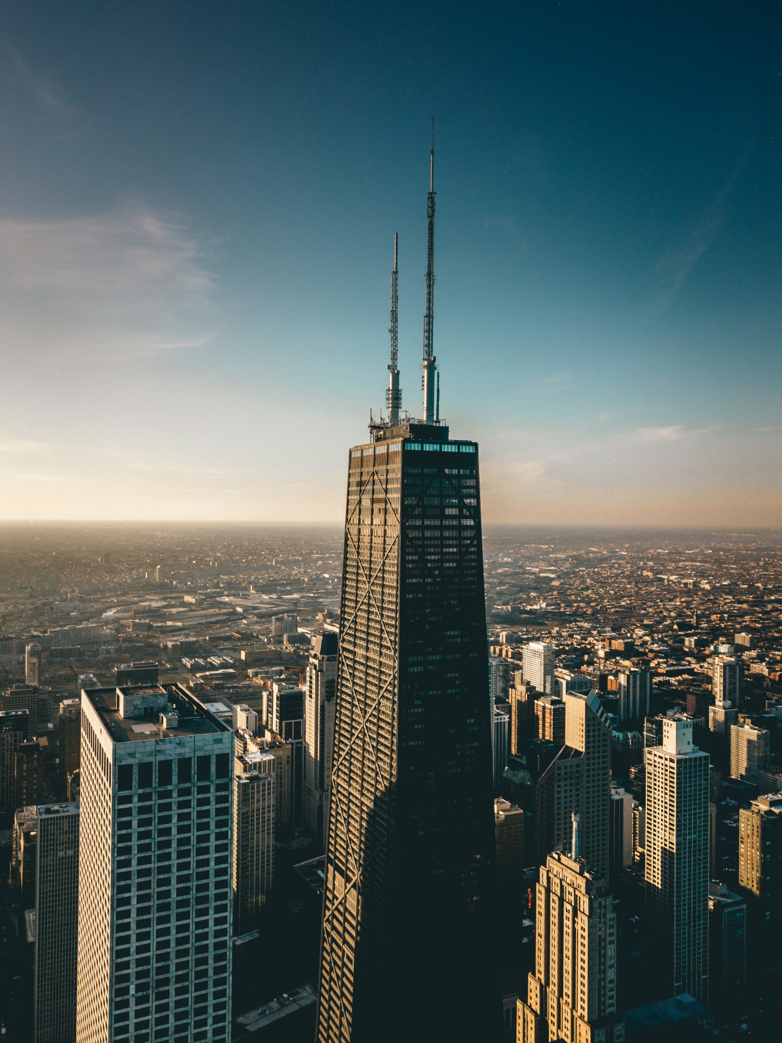 John Hancock Center towering above downtown Chicago skyline at sunset