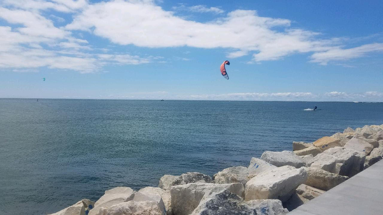 Kite surfers out on Lake Michigan near the rocky shoreline in Grand Haven, Michigan.