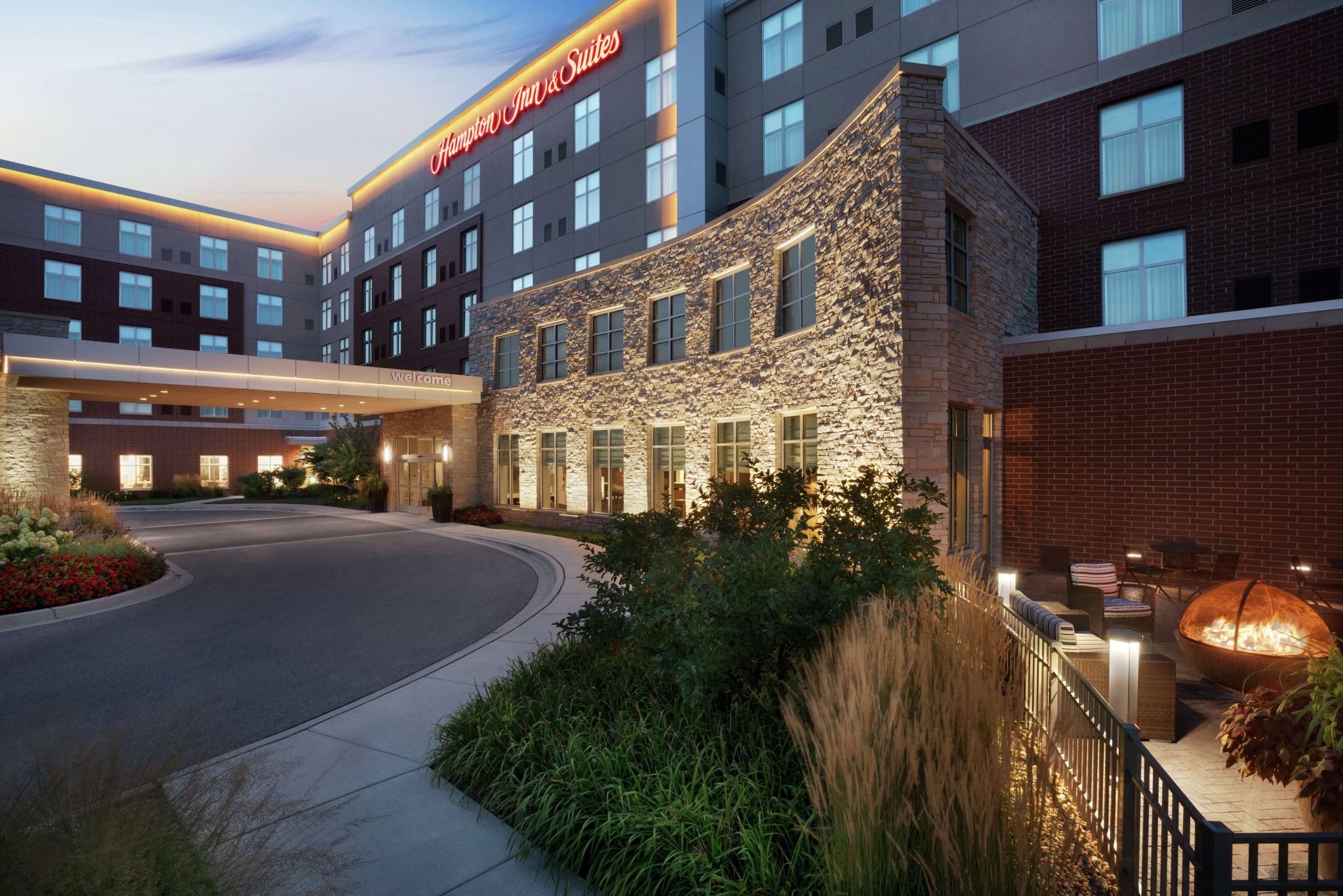 Exterior evening view of Hampton Inn & Suites near Rosemont Chicago with outdoor firepit seating area