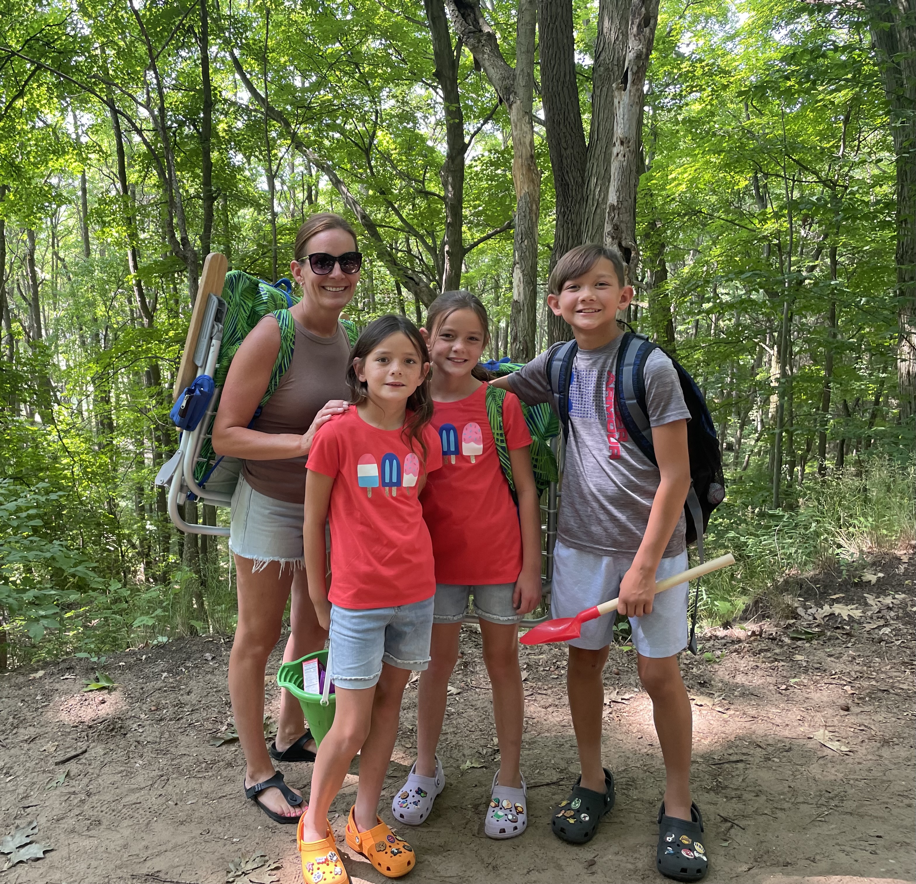 Family hiking through a wooded trail on the way to Oval Beach in Saugatuck Michigan