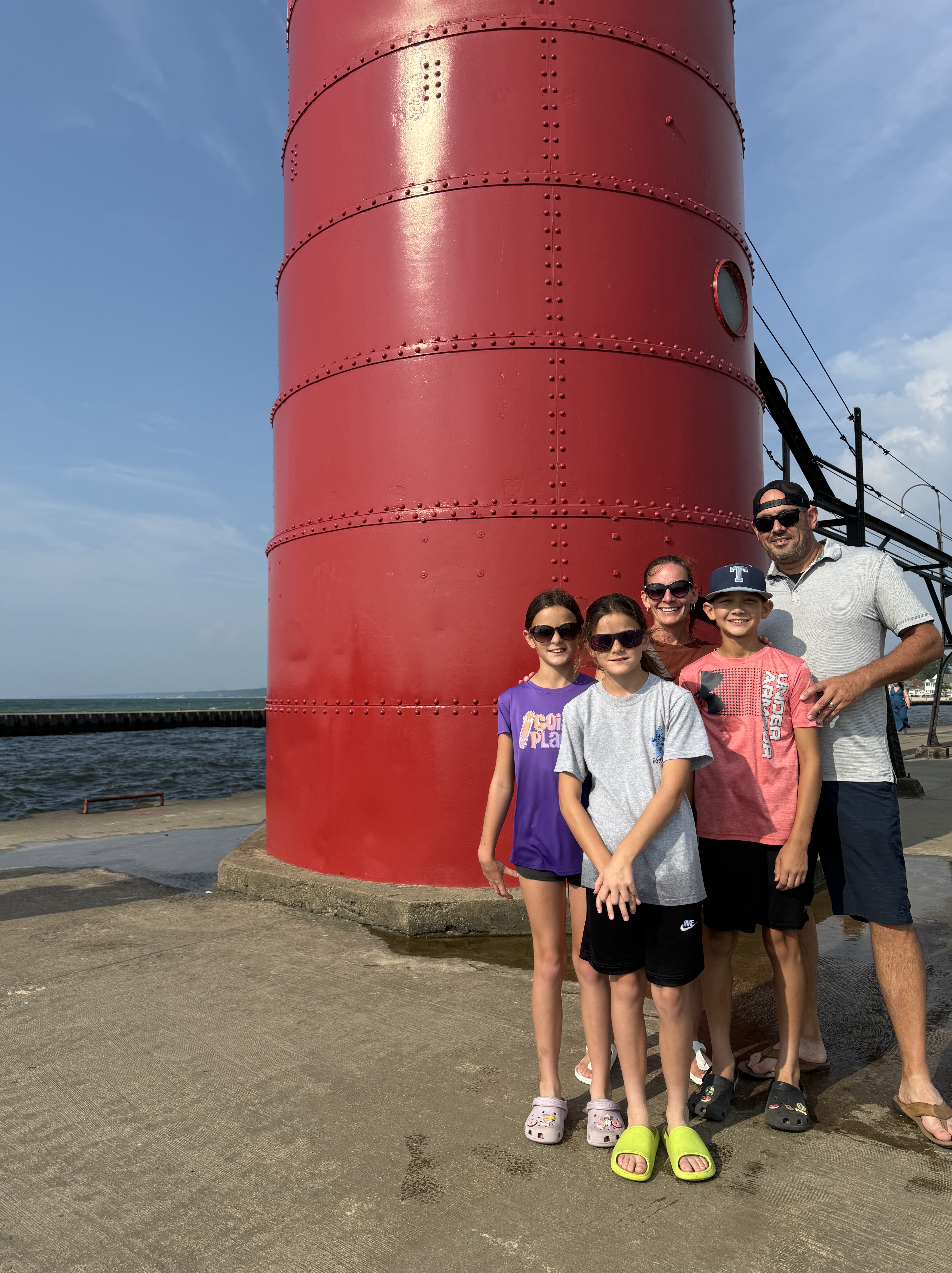 South Haven Lighthouse Family Photo Family standing by the red South Haven Lighthouse on Lake Michigan.