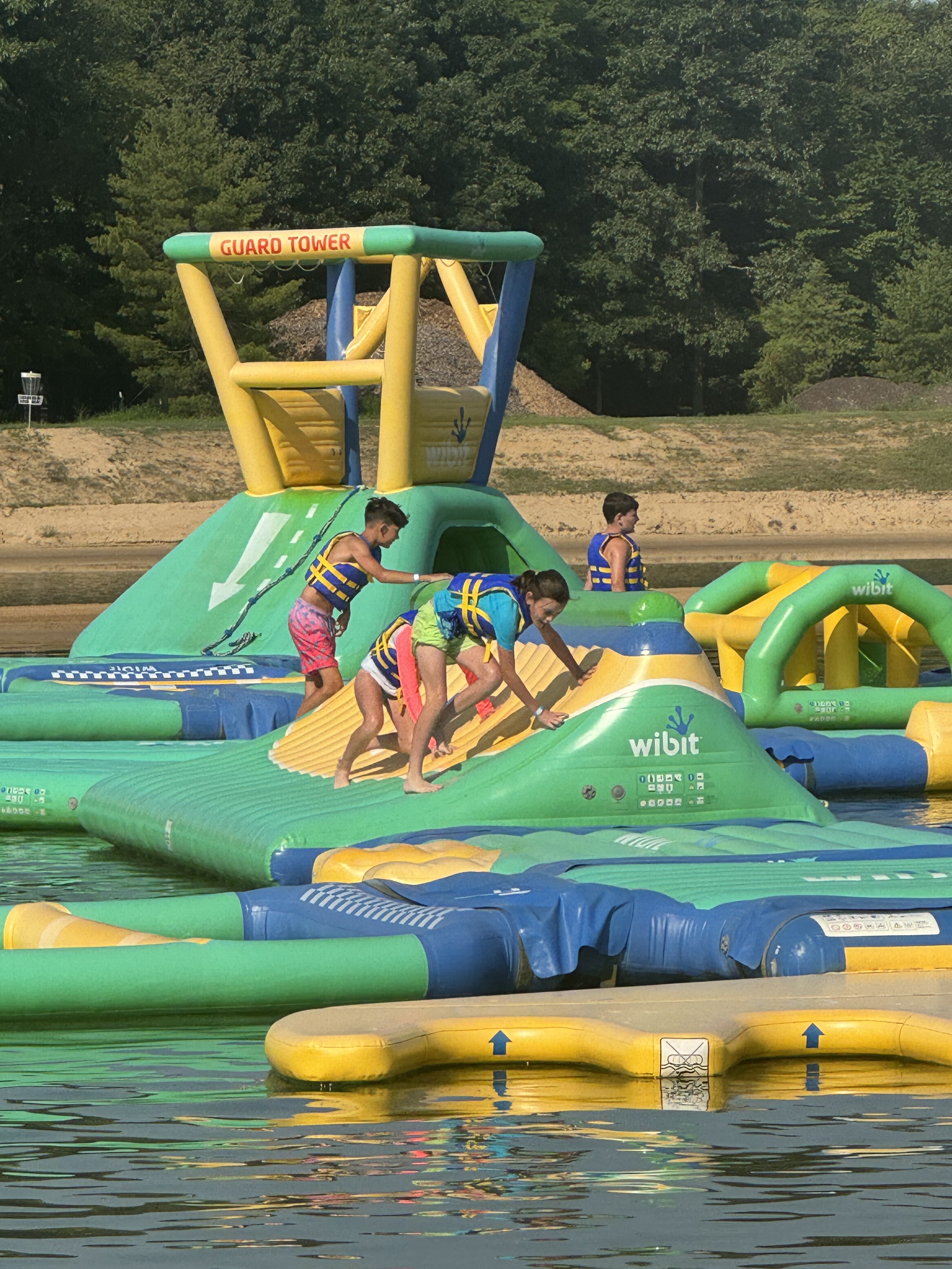 Kids Playing at Lake Arvesta Farms Kids climbing on inflatable water obstacles at Lake Arvesta Farms in South Haven, Michigan.