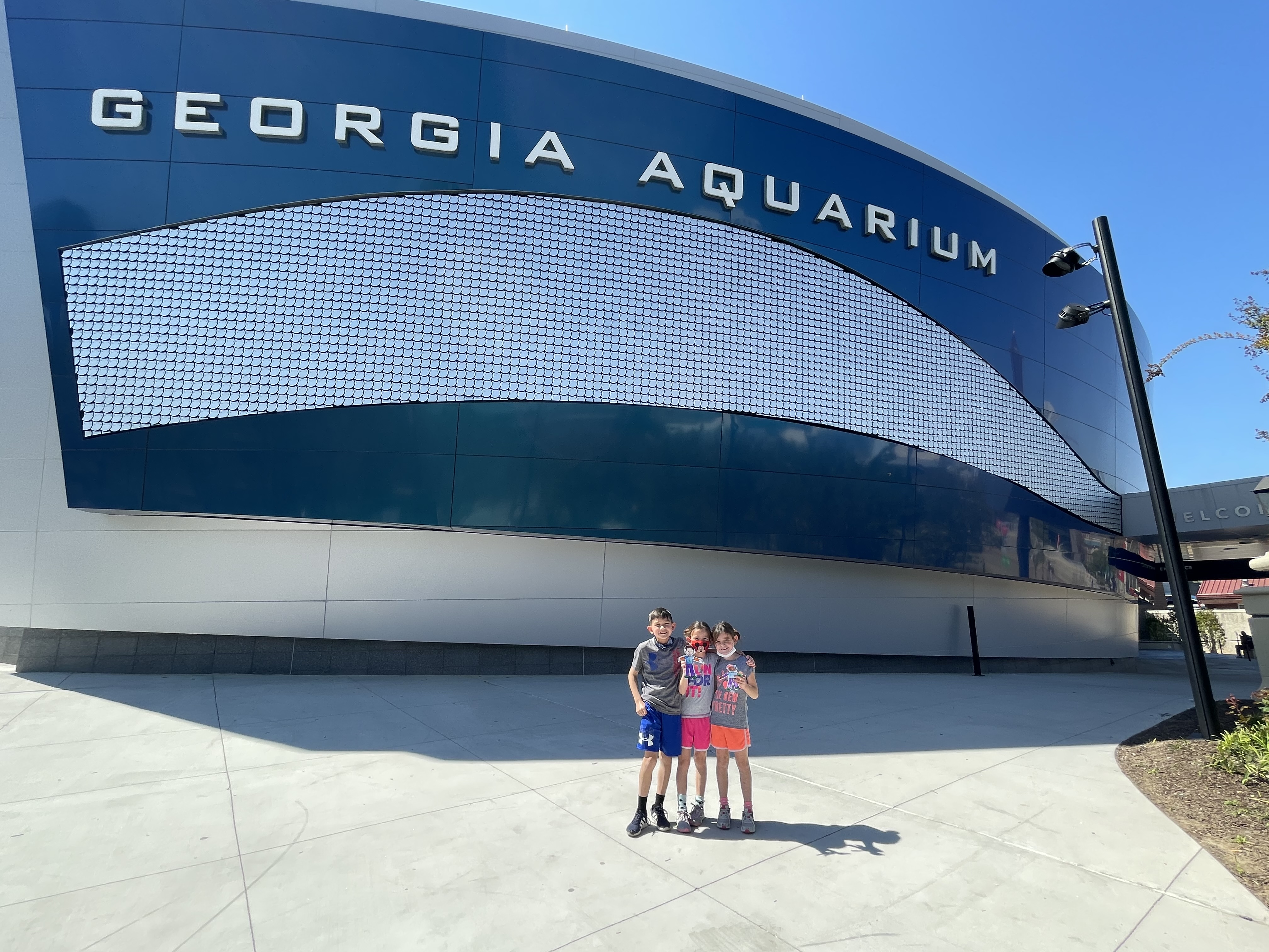 Kids standing outside the Georgia Aquarium during a family trip to Atlanta