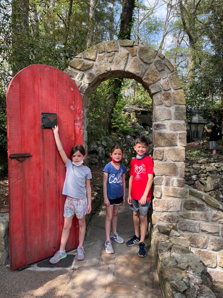 Kids standing beside the famous red door at Rock City Gardens on Lookout Mountain in Tennessee