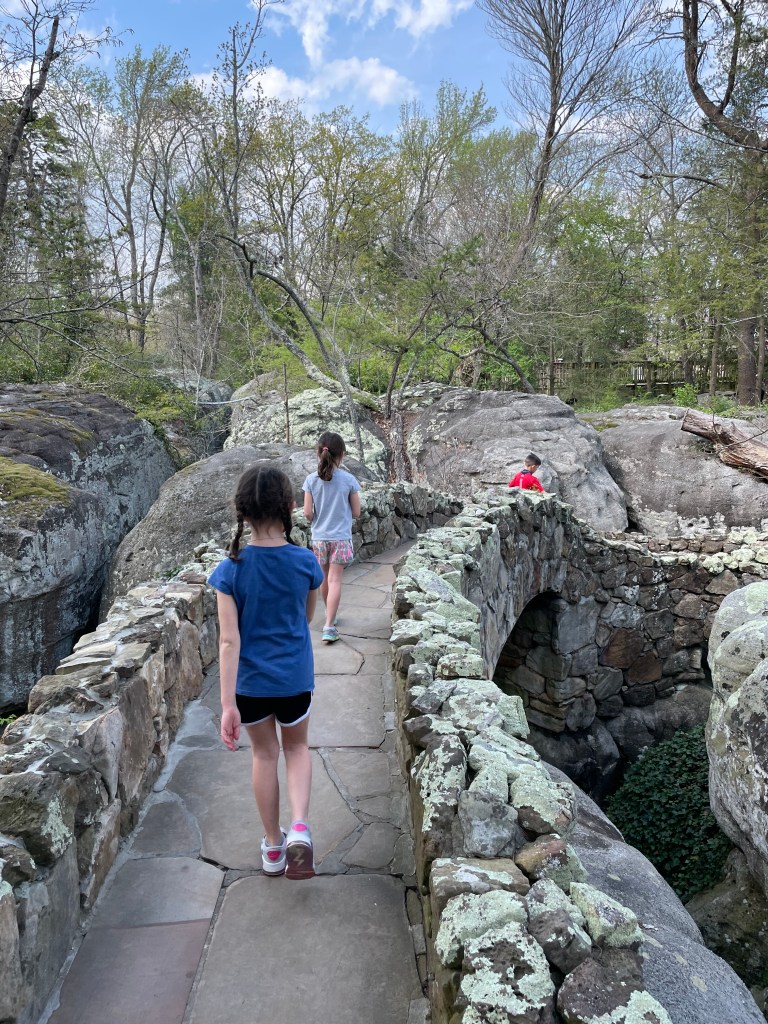 Kids walking across a stone bridge at Rock City Gardens on Lookout Mountain in Tennessee