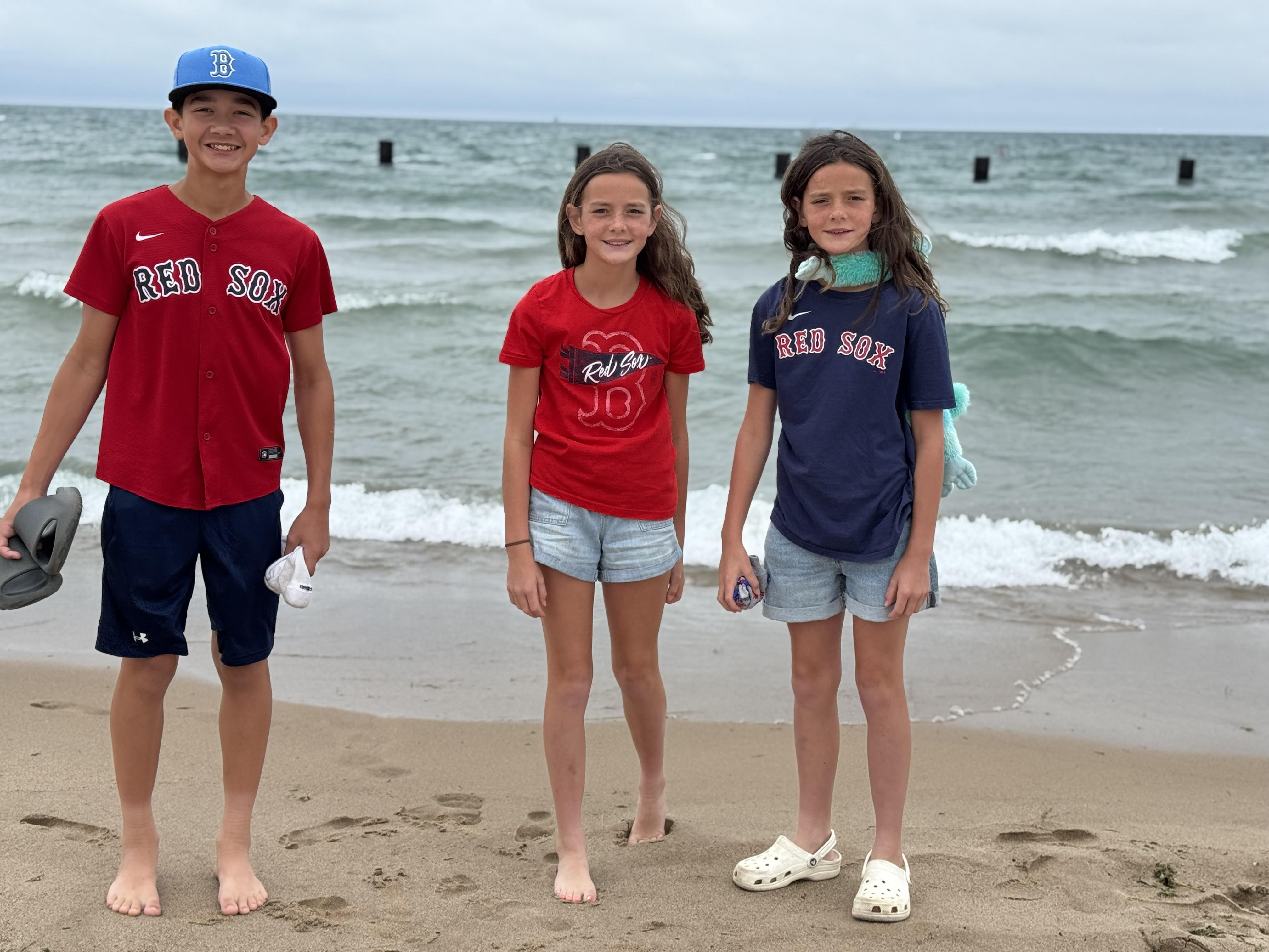 Kids standing on a Lake Michigan beach during a Chicago family trip