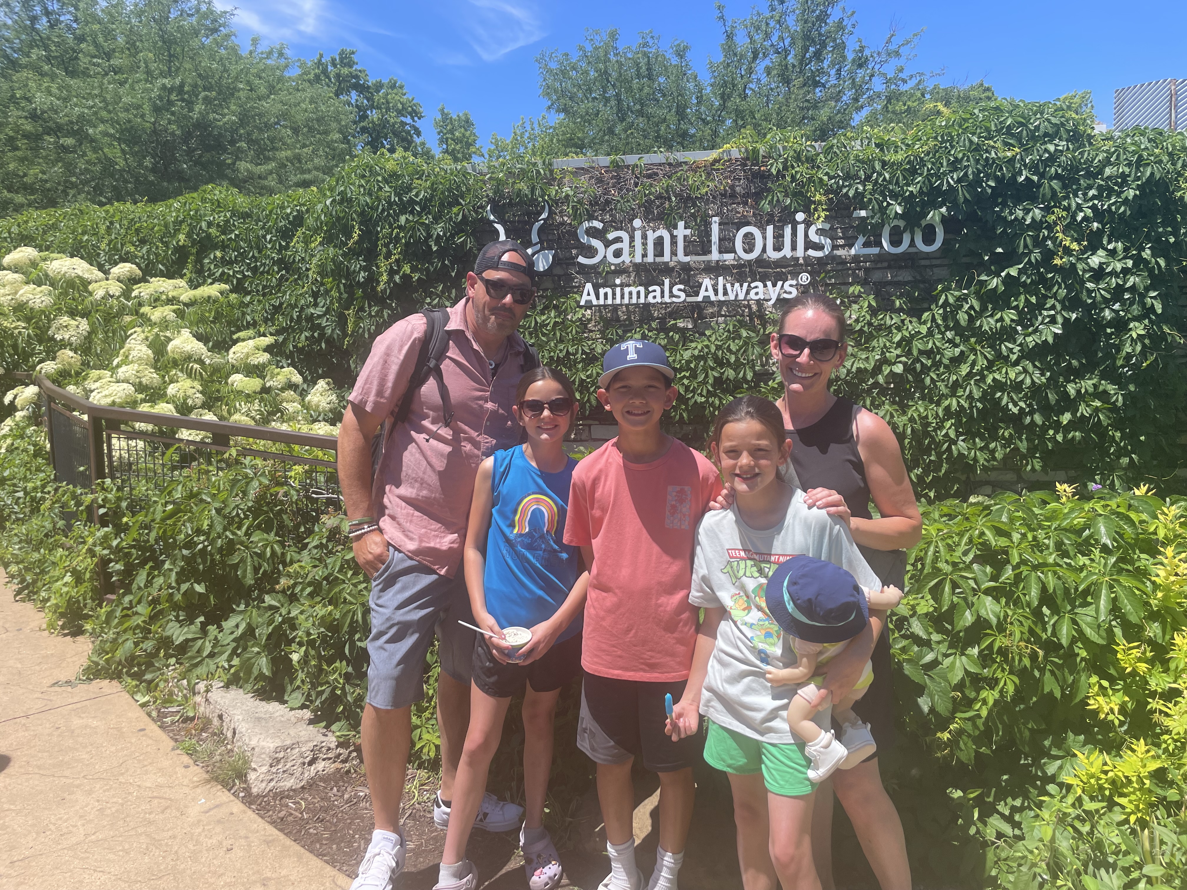 Family standing by the St. Louis Zoo sign in Missouri